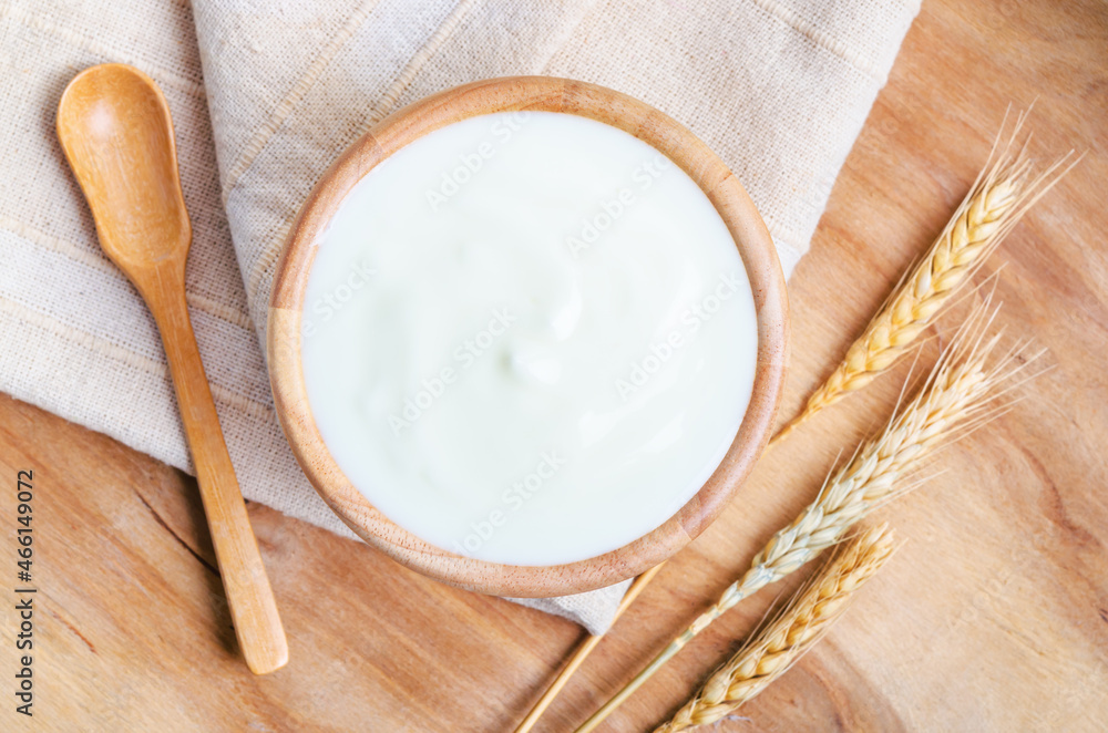 Greek yogurt in a wooden bowl and dry barley.