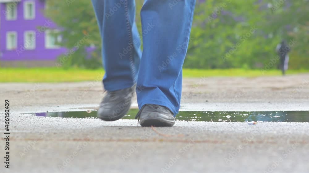 A man walks in a puddle in autumn and throws a cigarette on the road A man walks in a puddle in autumn and throws a cigarette on the road