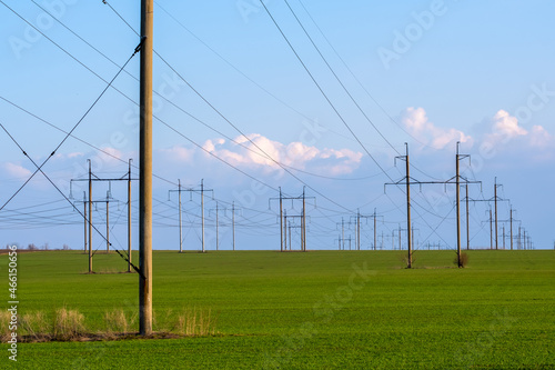 High-voltage power lines. Transmission of electricity by means of poles through agricultural land.
