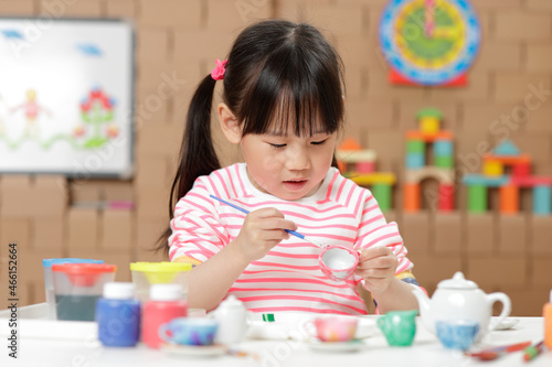 young girl painting tea set craft for home schooling