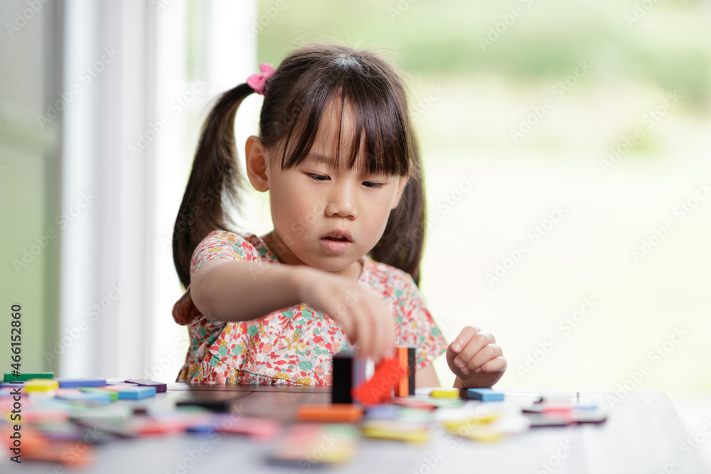young girl playing domino blocks at home young girl playing domino blocks at home