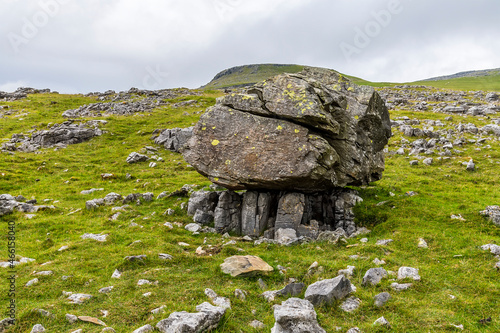 A view of a glacial erratic on limestones supports on the southern slopes of Ingleborough, Yorkshire, UK in summertime photo