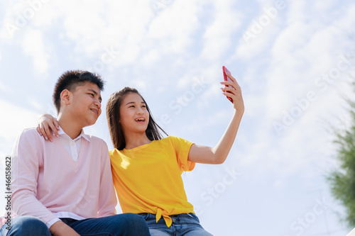 Self portrait of two asian teenager friends cloud sky background