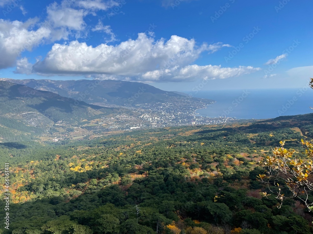 view of the seaside town and the overhanging clouds and autumn forest from the mountain view of the seaside town and the overhanging clouds and autumn forest from the mountain