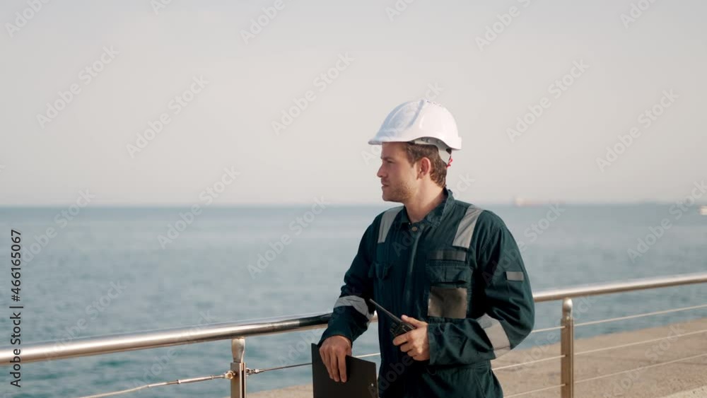 Port inspector in helmet and coverall filling vessel inspection checklist during control inspection Port inspector in helmet and coverall filling vessel inspection checklist during control inspection