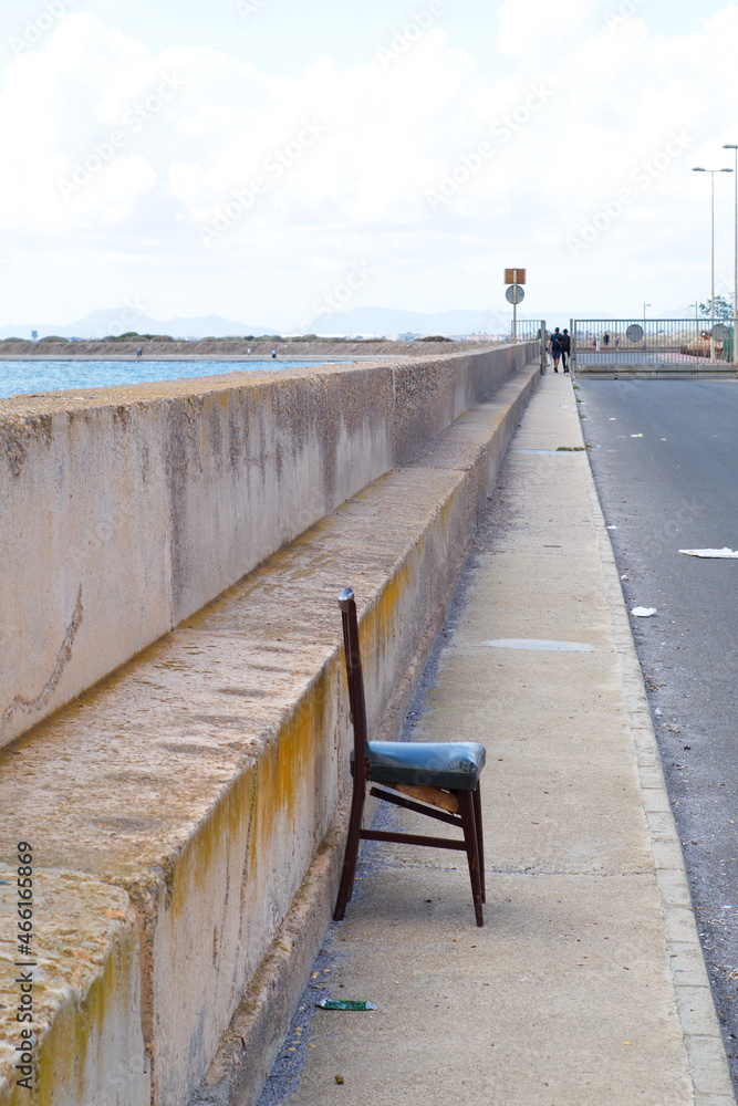 A deteriorated and isolated chair inside the fishing port
