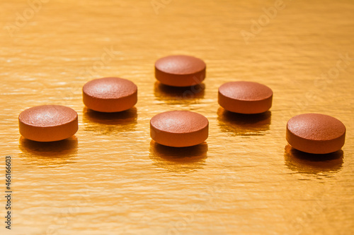 
pills, gold background, red, brown, round, health, vitamins, treatment, antiviral, drugs, dosage, stress, illness, recovery, medicine