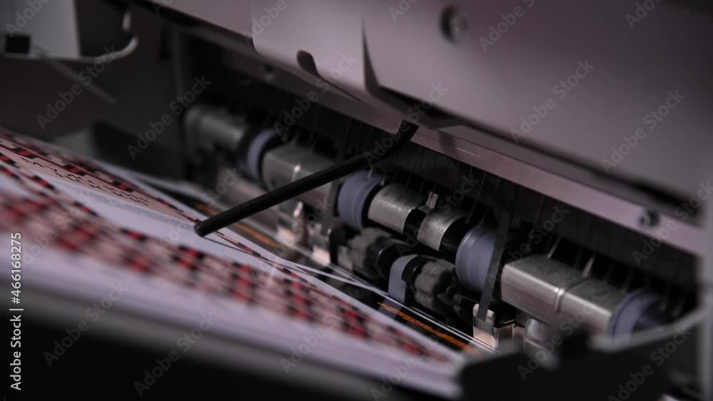 Close-up of an industrial printer output mechanism work. Paper exit after printing Close-up of an industrial printer output mechanism work. Paper exit after printing