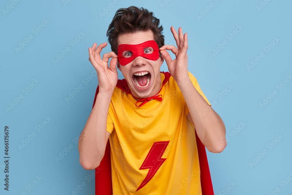 Excited superhero in mask screaming in studio Excited superhero in mask screaming in studio