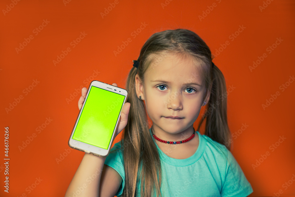 Child vertically holding smartphone with green screen. Child vertically holding smartphone with green screen.