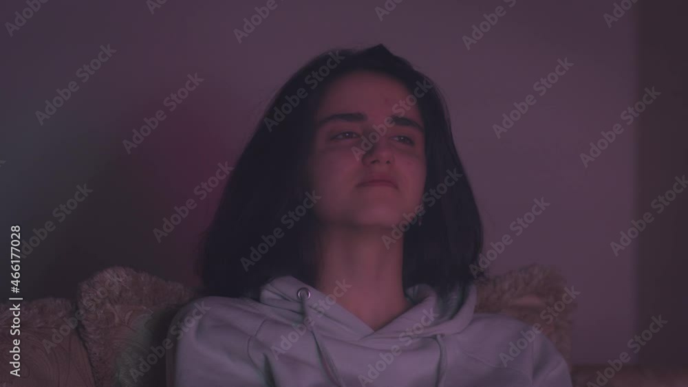Girl watching TV at night, multicolored lighting Girl watching TV at night, multicolored lighting