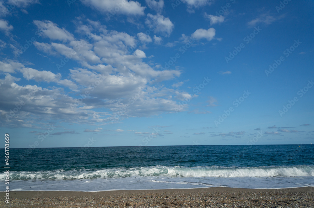 summer day at a beach. view of the sea with waves at a sunny day