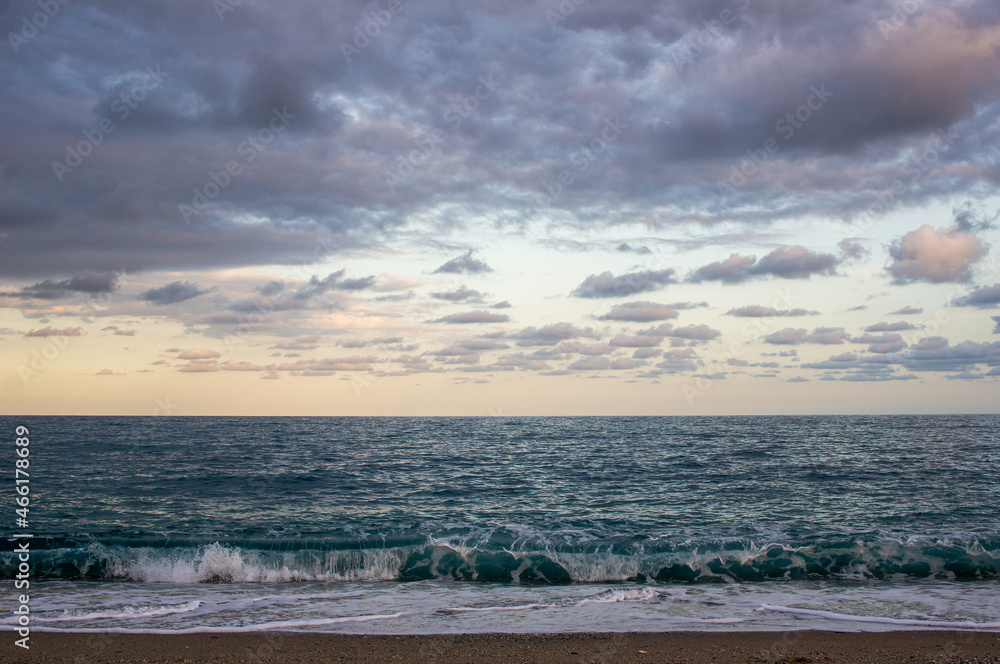 sea. waves at beach small clouds at sunset. horizontal