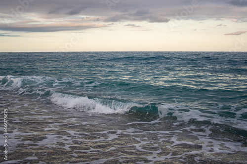 small wave crashing at a beach in crystal clear water