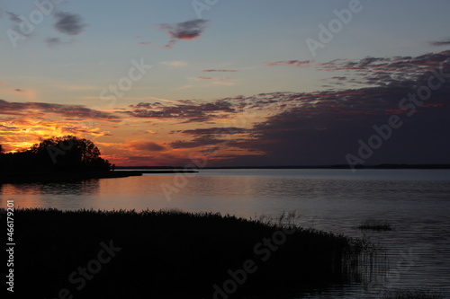 Sunset over a lake with a cloudy sky illuminated by the setting sun rural landscape of Russia