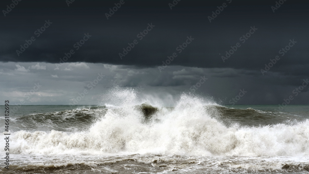 Panoramic view of a stormy sea and dark sky, waves are crashing on the shore