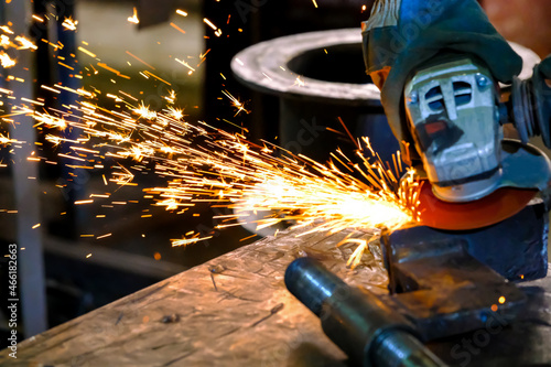 Rotation of the angle grinder disc during operation. Bright sparks from metal cutting. Preparation of metal structures before welding.