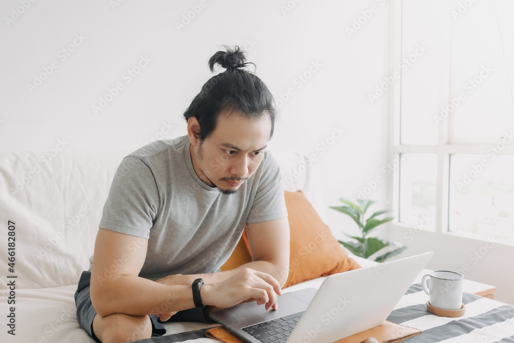 Serious creative asian man work in his home office apartment.
