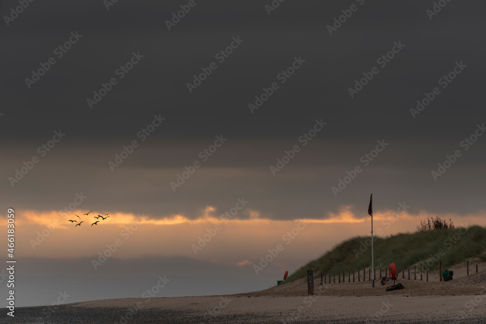 Beautiful sunrise landscape image of Talacre beach at surnise with dramatic sky and clouds