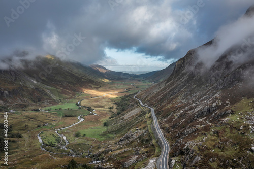 Aerial view of flying drone Epic landscape image in Autumn looking down Nant Fracon valley from Llyn Idwal with moody sky and copyspace photo