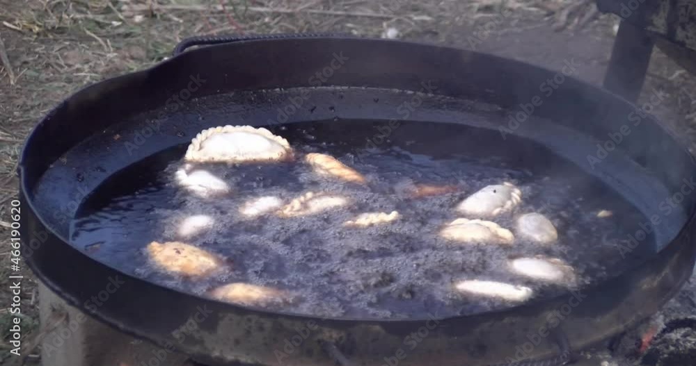 Fried empanadas. Empanadas cooking in oil. Pot with boiling oil cooking empanadas. Typical Argentine food. Argentina. Outdoor kitchen. Fried foods. Fried empanadas. Empanadas cooking in oil. Pot with boiling oil cooking empanadas. Typical Argentine food. Argentina. Outdoor kitchen. Fried foods.