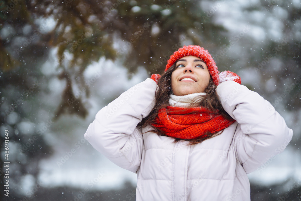 Winter smiling woman in red hat posing in a snowy park. Cold weather. Winter fashion, holidays, rest, travel concept. Winter smiling woman in red hat posing in a snowy park. Cold weather. Winter fashion, holidays, rest, travel concept.