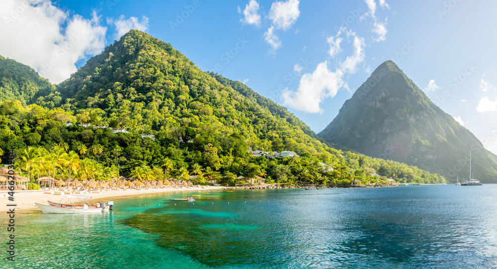 Caribbean beach with palms and straw umrellas on the shore with Gros Piton mountain in the background, Sugar beach, Saint  Lucia - obrazy, fototapety, plakaty 