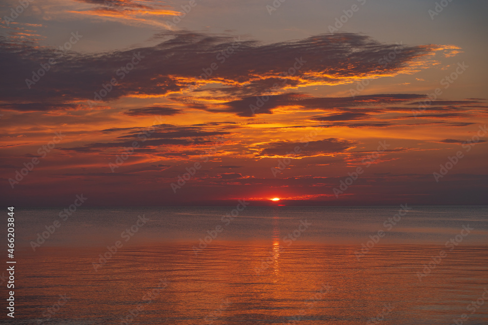 sunset in the sea with clouds and calm water