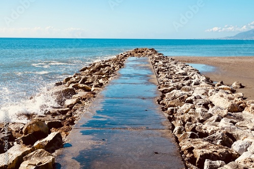 Mediterranean Sea at the end of a small path between rocks on a beach on the Costa del Sol  Spain 