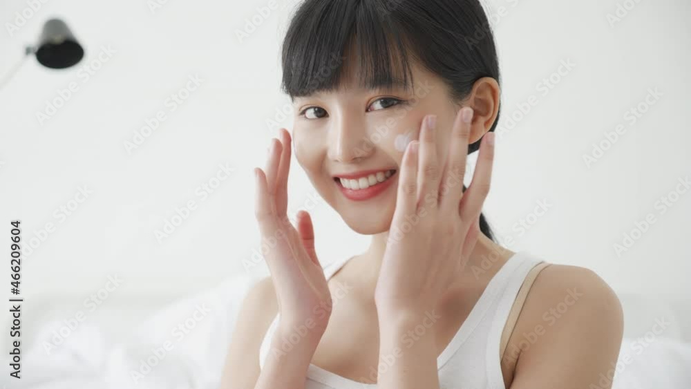 Beautiful young asian woman happy applying cream or lotion with moisturizer to skin on face, beauty asia girl applying skincare touch facial with cosmetic makeup, skin care and health concept. Beautiful young asian woman happy applying cream or lotion with moisturizer to skin on face, beauty asia girl applying skincare touch facial with cosmetic makeup, skin care and health concept.