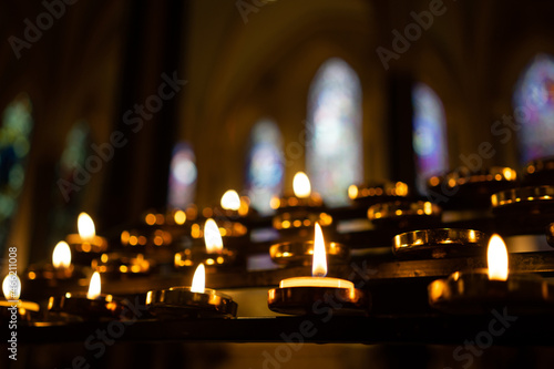 candles in church against stained glass windows