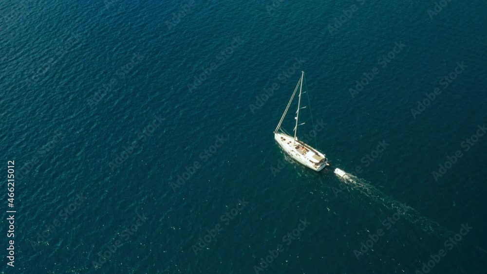 White sailboat or yacht sails on the sea with blue water. Aerial view of Adriatic sea and vessel White sailboat or yacht sails on the sea with blue water. Aerial view of Adriatic sea and vessel