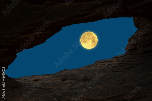 Big full moon in blue sky in cave entrabce view photo