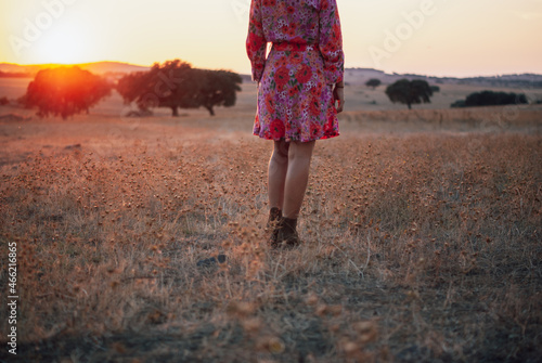Women ia a red flower dress walking on a Cork Oak field