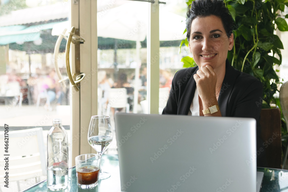 portrait of a smiling business friend, working online at the table of a cafeteria restaurant portrait of a smiling business friend, working online at the table of a cafeteria restaurant