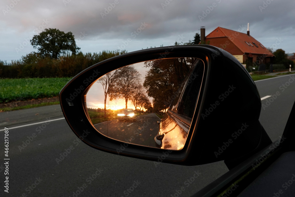 Sonnenuntergang im Rückspiegel eines Autos