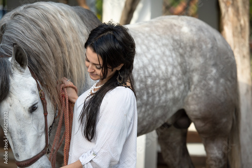 beautiful  woman with her  grey young Andalusian stallion posing in garden. Spain, Andalusia