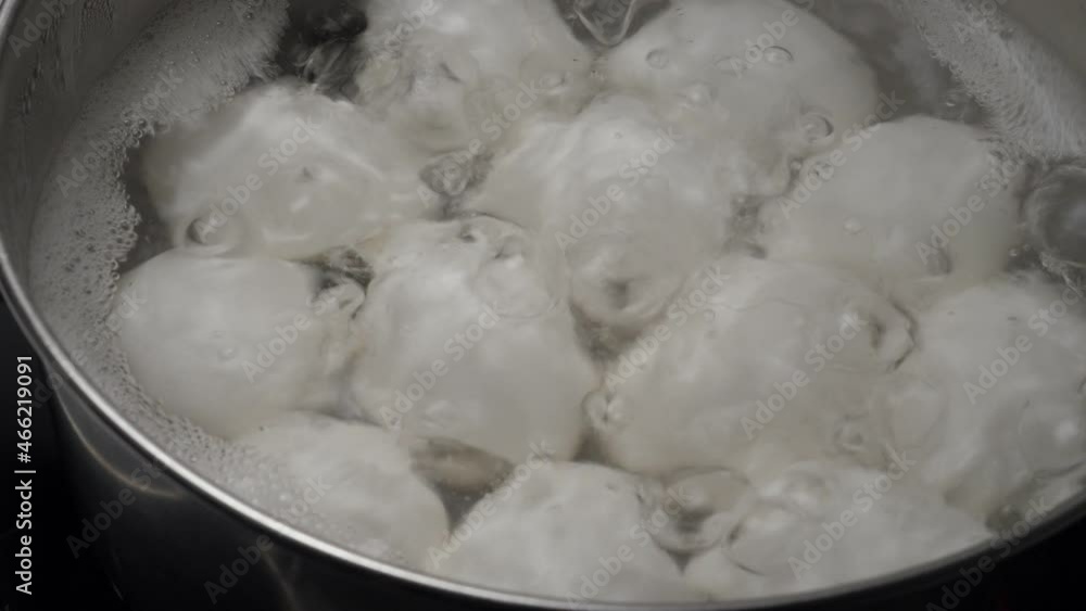 White Chicken eggs boiling in stainless steel pan, closeup White Chicken eggs boiling in stainless steel pan, closeup
