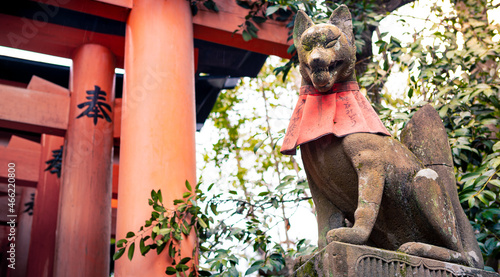 Canvas Print Kitsune japanese fox statue with red apron at famous Fushimi Inari Taisha shrine