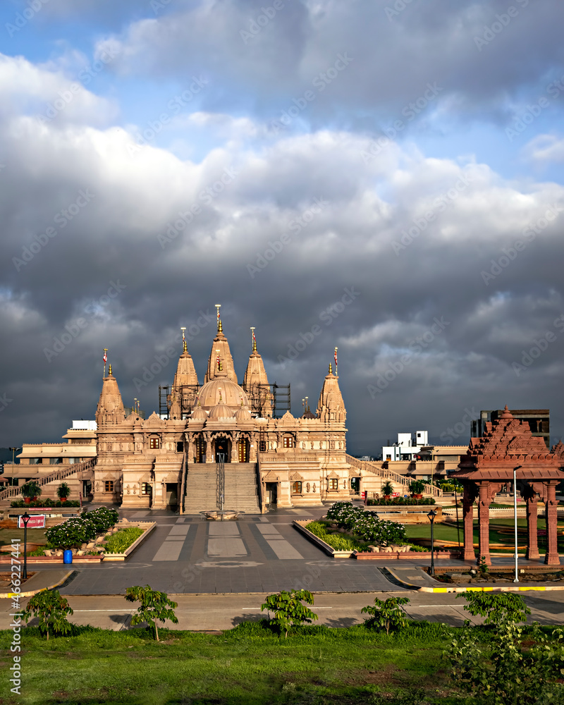 Crowdless Swaminarayan temple on a clear sunny day with clouds background in Ambegaon, Pune, Maharashtra, India.