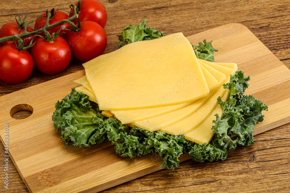 Sliced Gauda cheese over board Sliced Gauda cheese over board