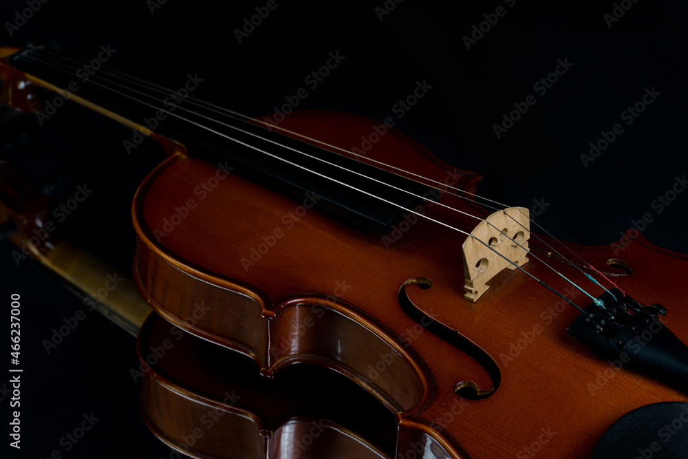 Dramatic close up of red violin on black background. Musical instrument. Classic music concept. Dramatic close up of red violin on black background. Musical instrument. Classic music concept.