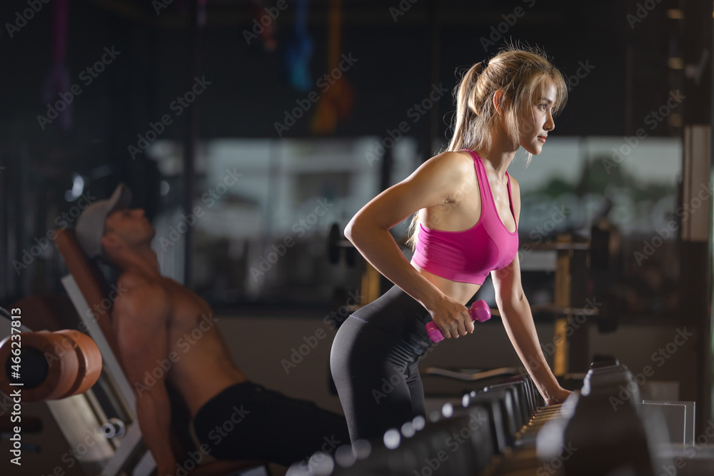 woman exercising with dumbbells in gym woman exercising with dumbbells in gym