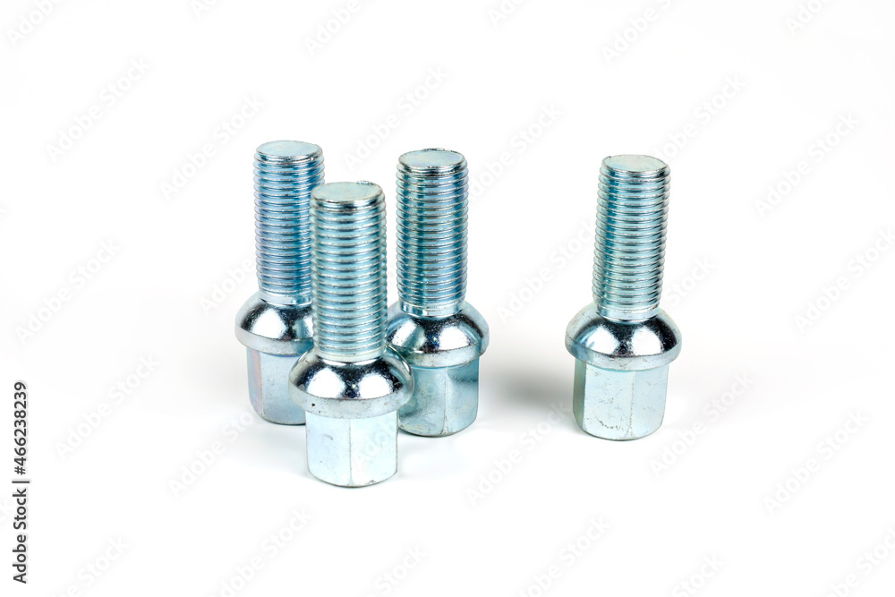 Large car wheel bolts made of silver metal. Isolated over white background. close-up Large car wheel bolts made of silver metal. Isolated over white background. close-up