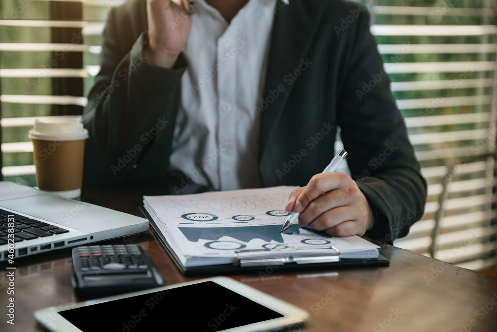 Fototapeta premium Male writes information businessman working on laptop computer writing business plan while sitting in office.
