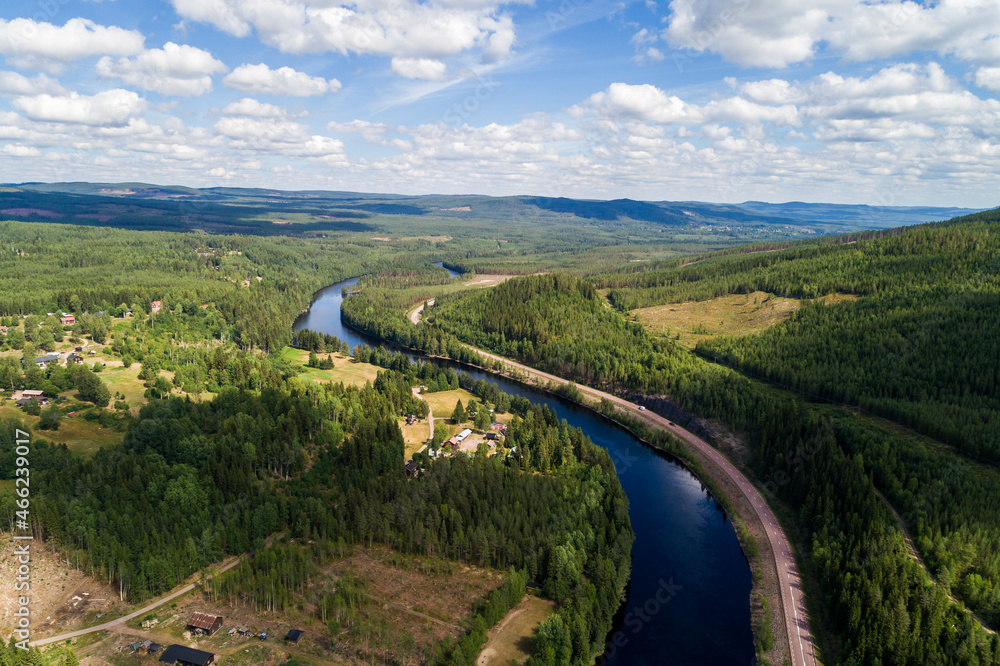 River and road running through forest and mountainous landscape ,aerial view 