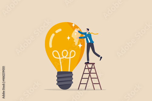 Polishing idea or finalize to be perfect and best quality result, attention to details, craftsmanship concept, smart businessman climb up ladder to clean and polish lightbulb for best quality idea. photo