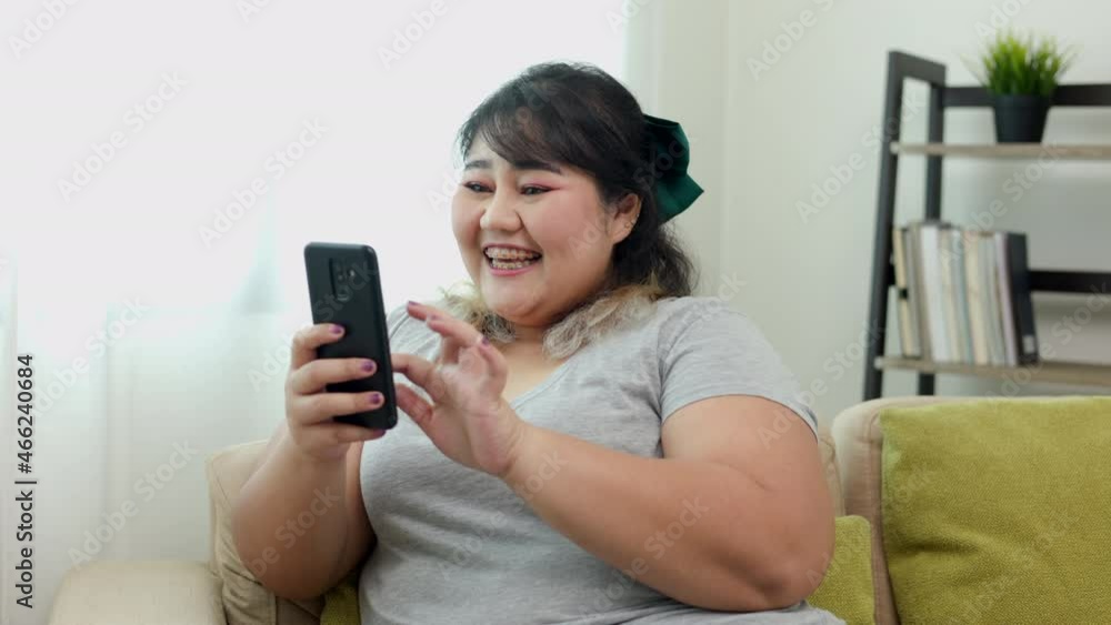 Body positive plus size woman holding mobile phone taking selfie photo using smartphone camera. Body positive plus size female lives happily and is proud of herself. Body positive plus size woman holding mobile phone taking selfie photo using smartphone camera. Body positive plus size female lives happily and is proud of herself.