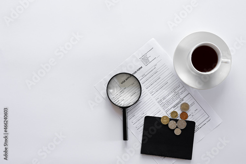 Visa application form, documents and a cup of coffee on a white background.