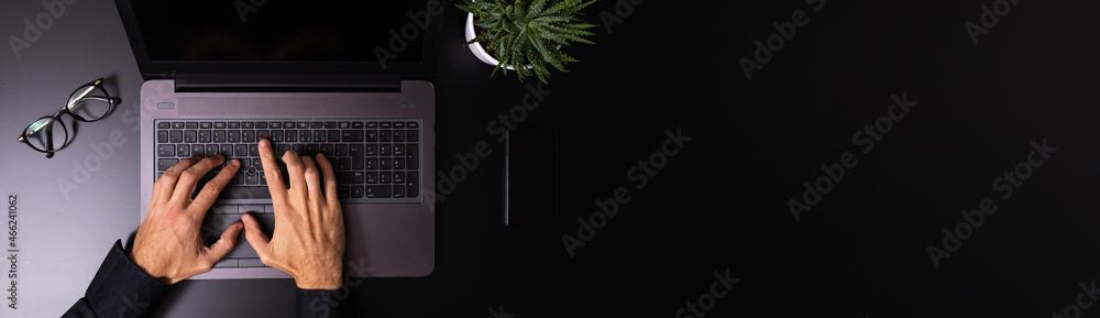 Person using a laptop computer on a solid color background Person using a laptop computer on a solid color background